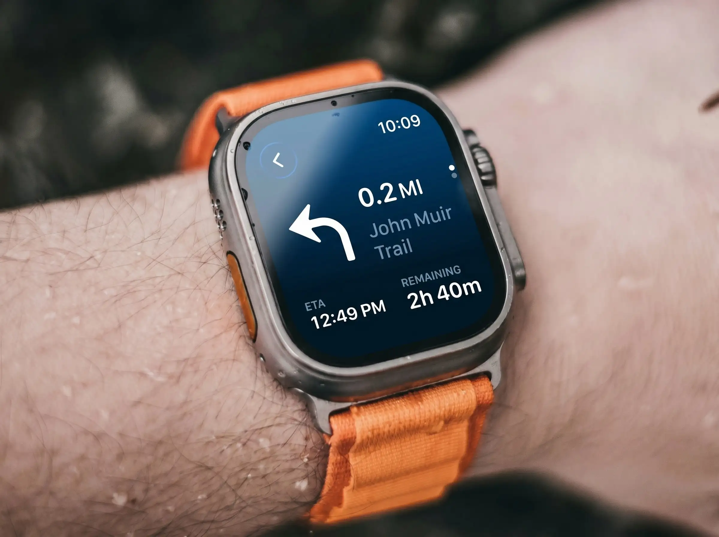 Apple Watch Ultra showing WristTopo turn-by-turn guidance: a large left arrow, distance to the next turn, the trail name, ETA and remaining time